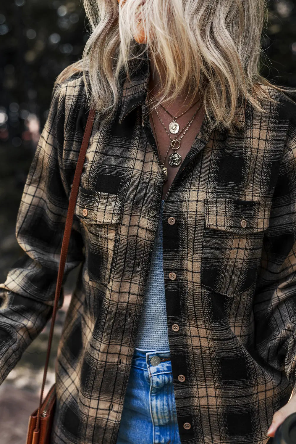 Person wearing a plaid shirt with a blurred background