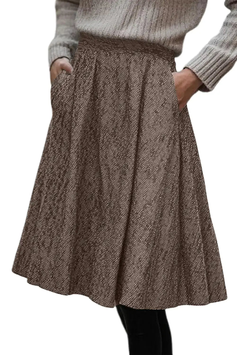 A brown and beige textured herringbone skirt with side pockets, worn by a model in a gray ribbed sweater against a white background.