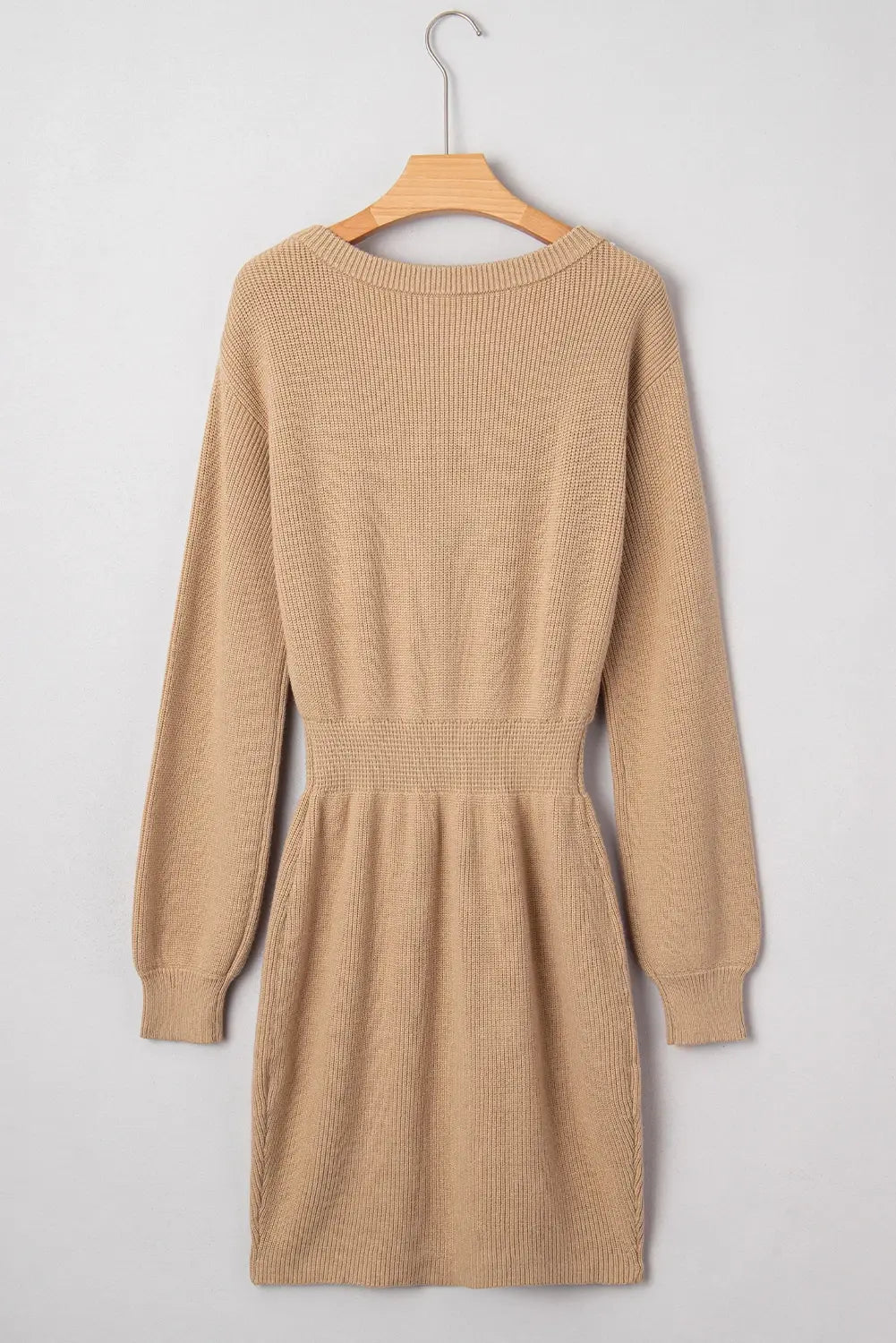 Beige ribbed dress on a wooden hanger against a light gray background