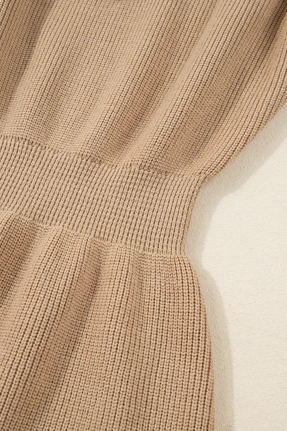 Close-up of a beige knitted sweater on a light background