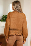 Woman wearing a brown suede jacket with lace detailing indoors.