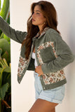 Woman wearing a green jacket with floral patterns and light blue shorts against a white background