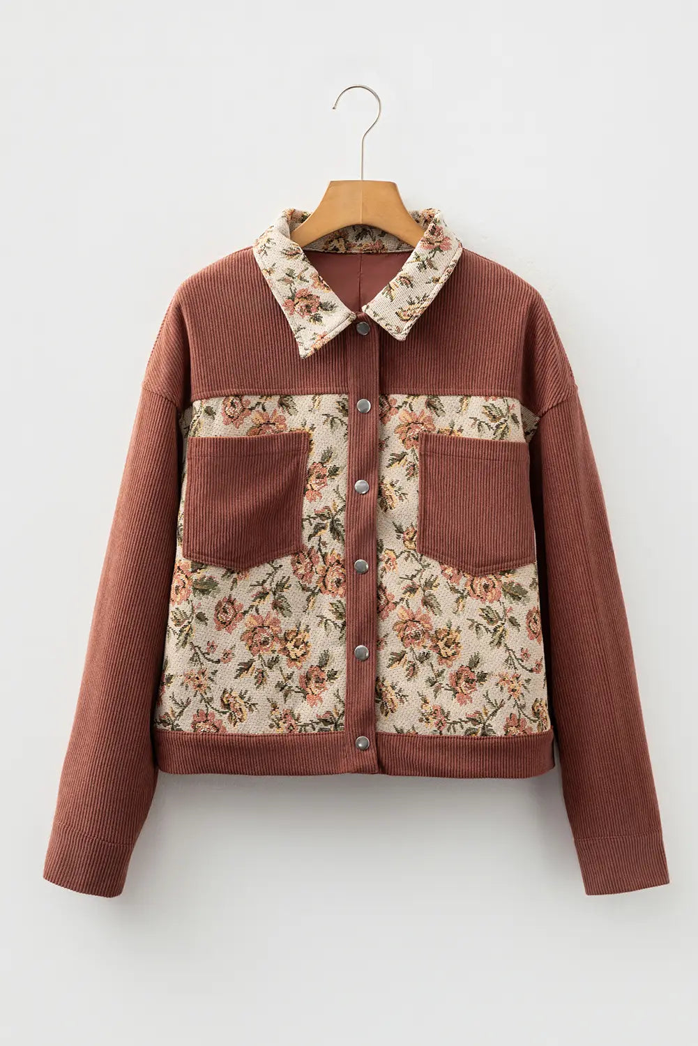 Floral-patterned jacket with brown accents on a hanger against a white background