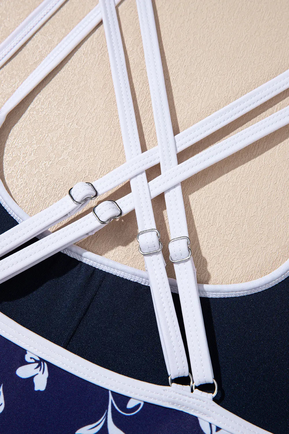 Close-up of white straps on a navy and beige fabric background