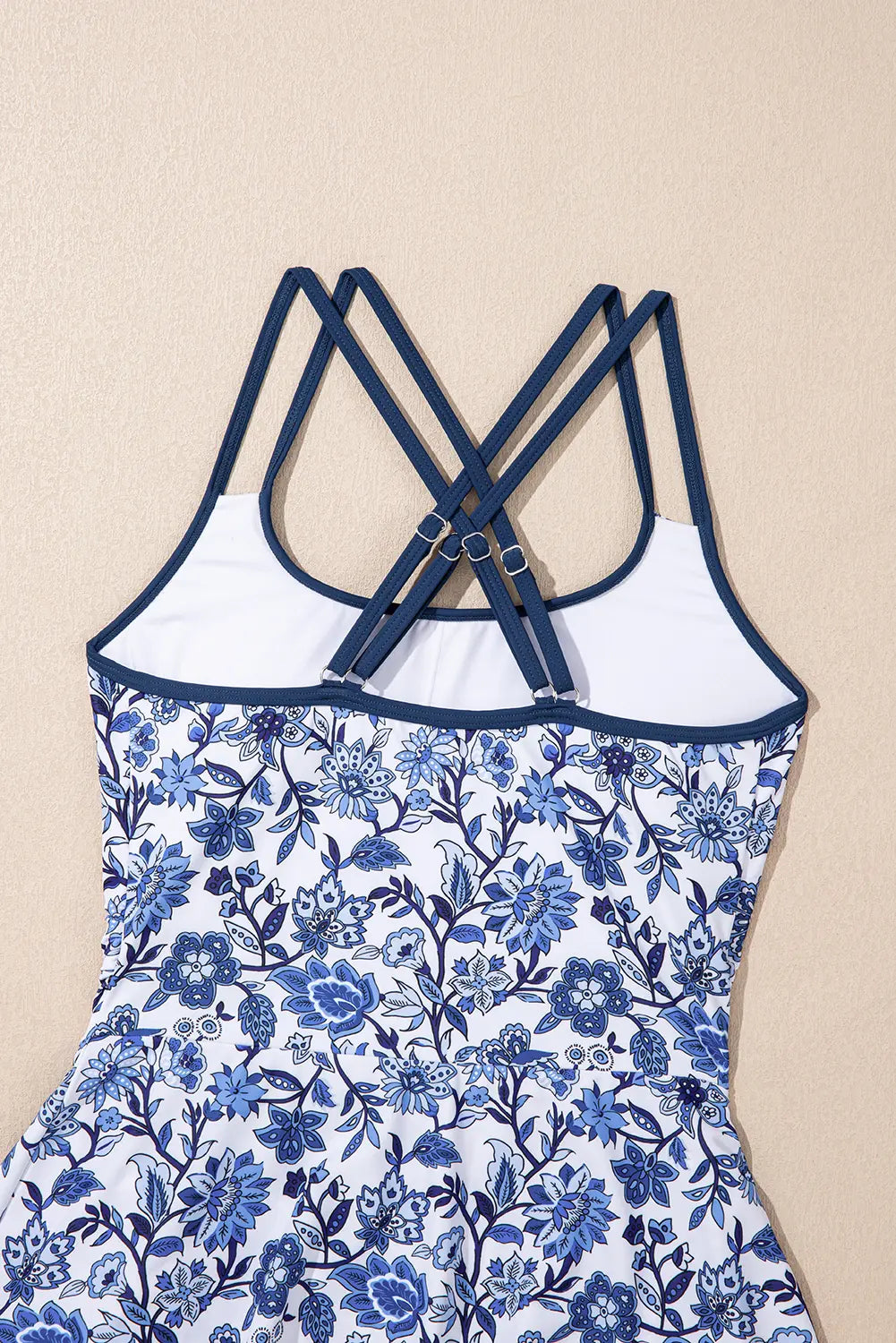 Blue floral dress with white straps on a beige background