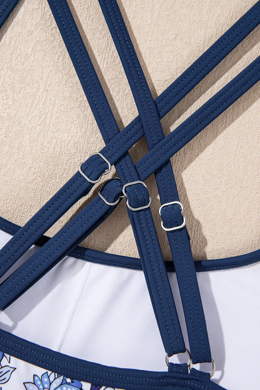 Close-up of blue equestrian bridle straps on a textured beige and white background
