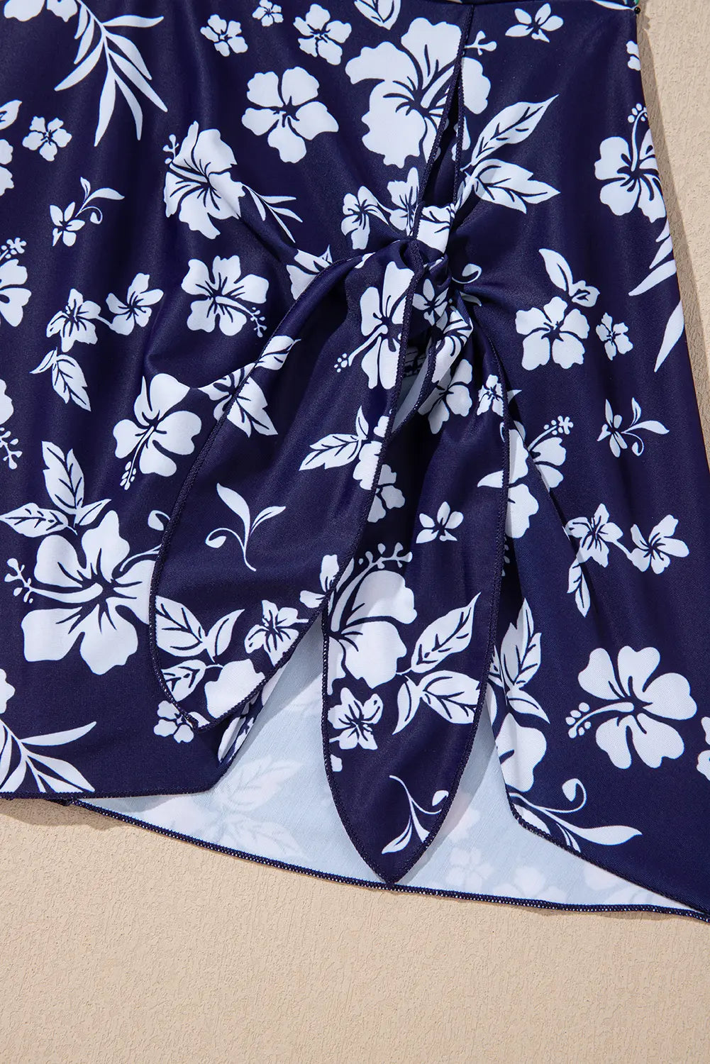 Navy blue fabric with white floral pattern on a beige background