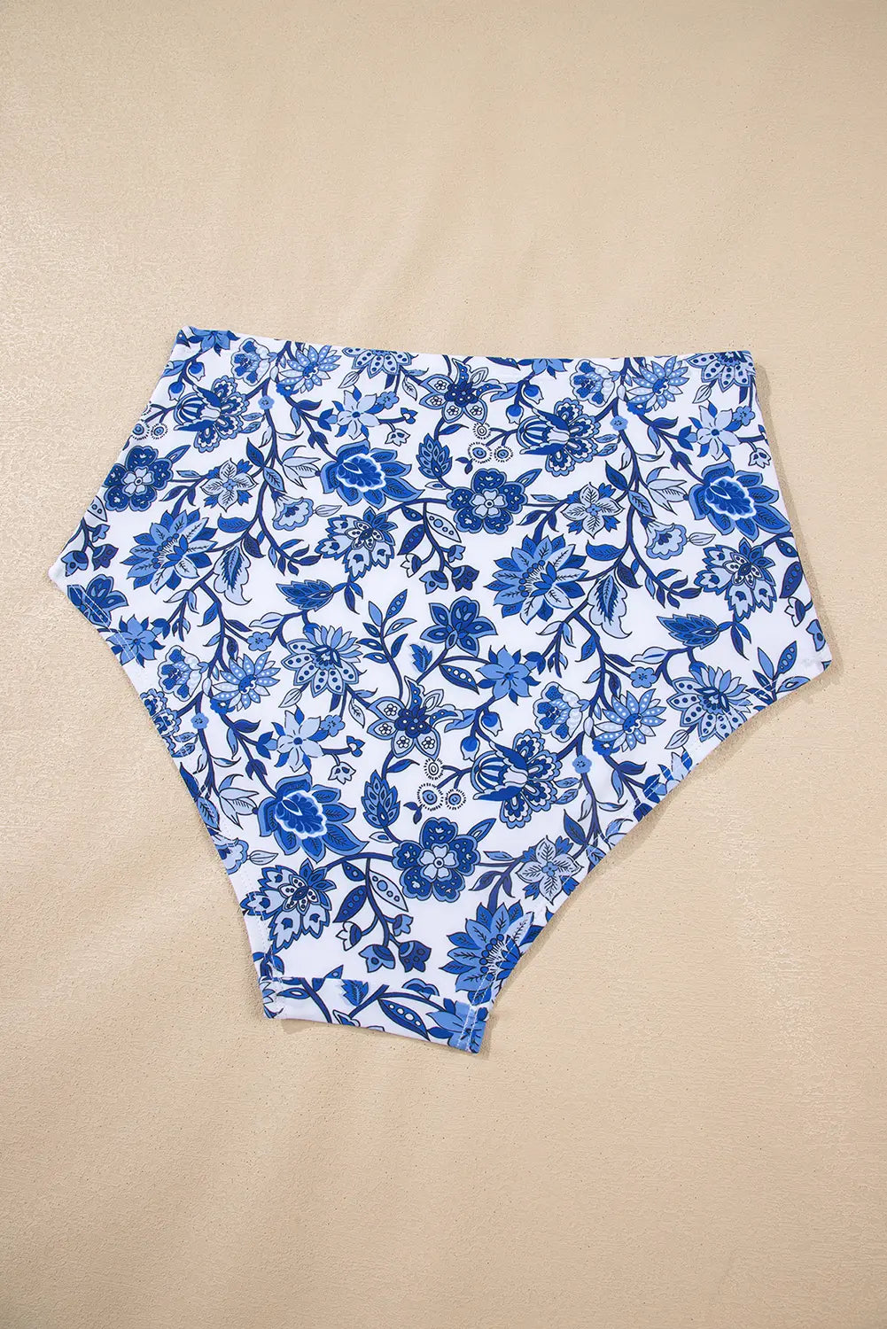 Blue and white floral print high-waisted briefs laid flat on a beige background.