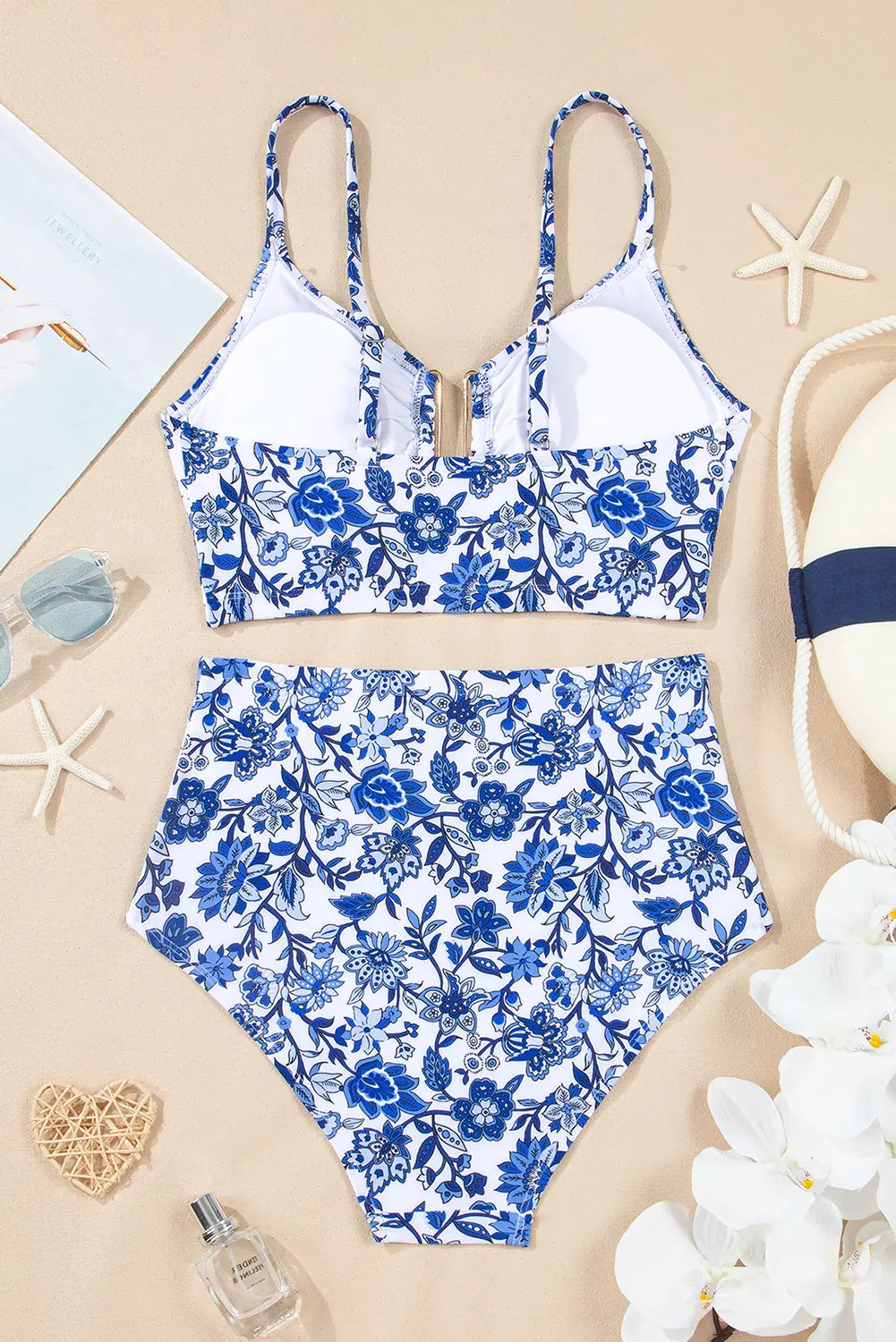 Blue floral swimsuit on a beige background with starfish and flowers.
