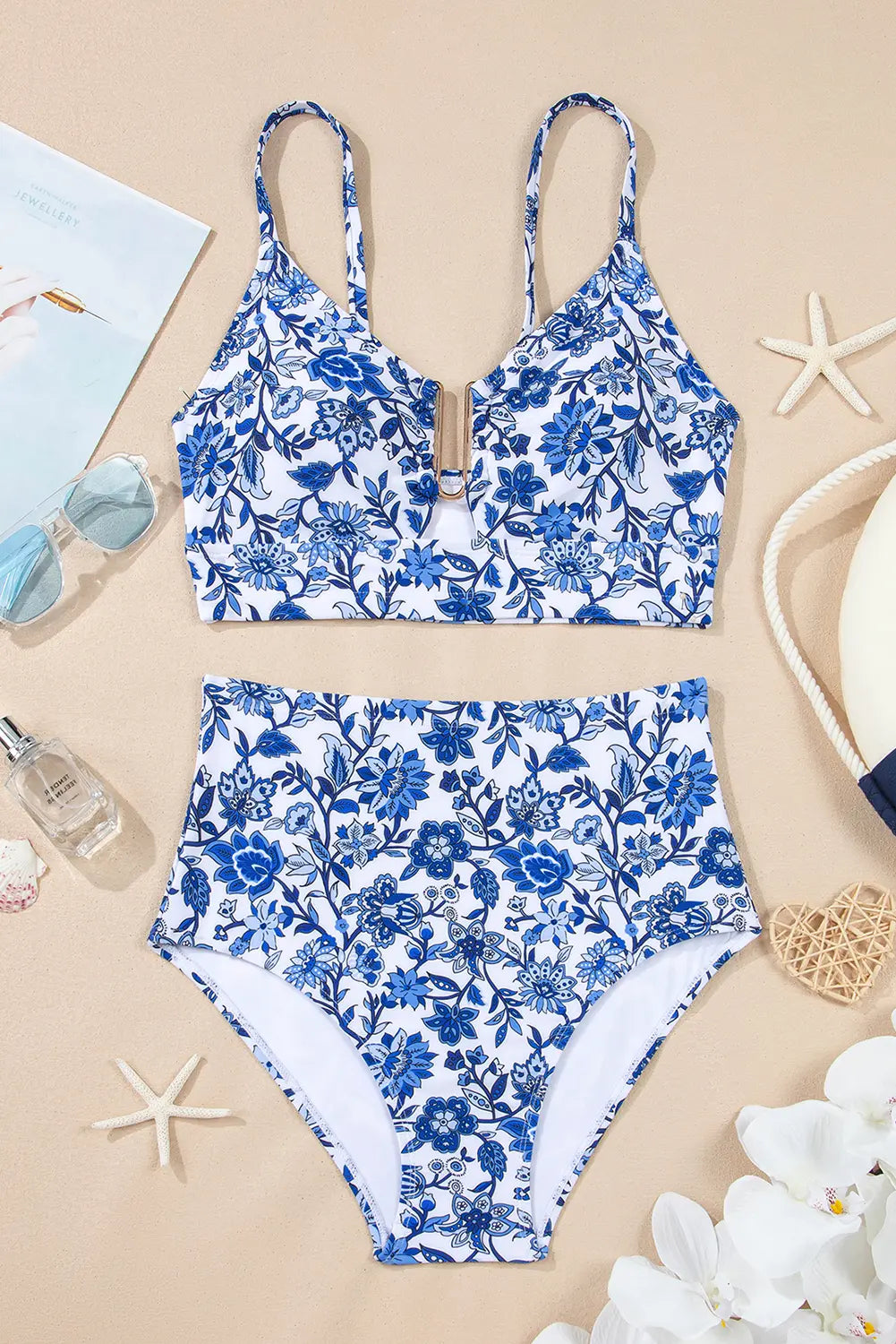 Blue floral swimsuit on a beige background with starfish and flowers.