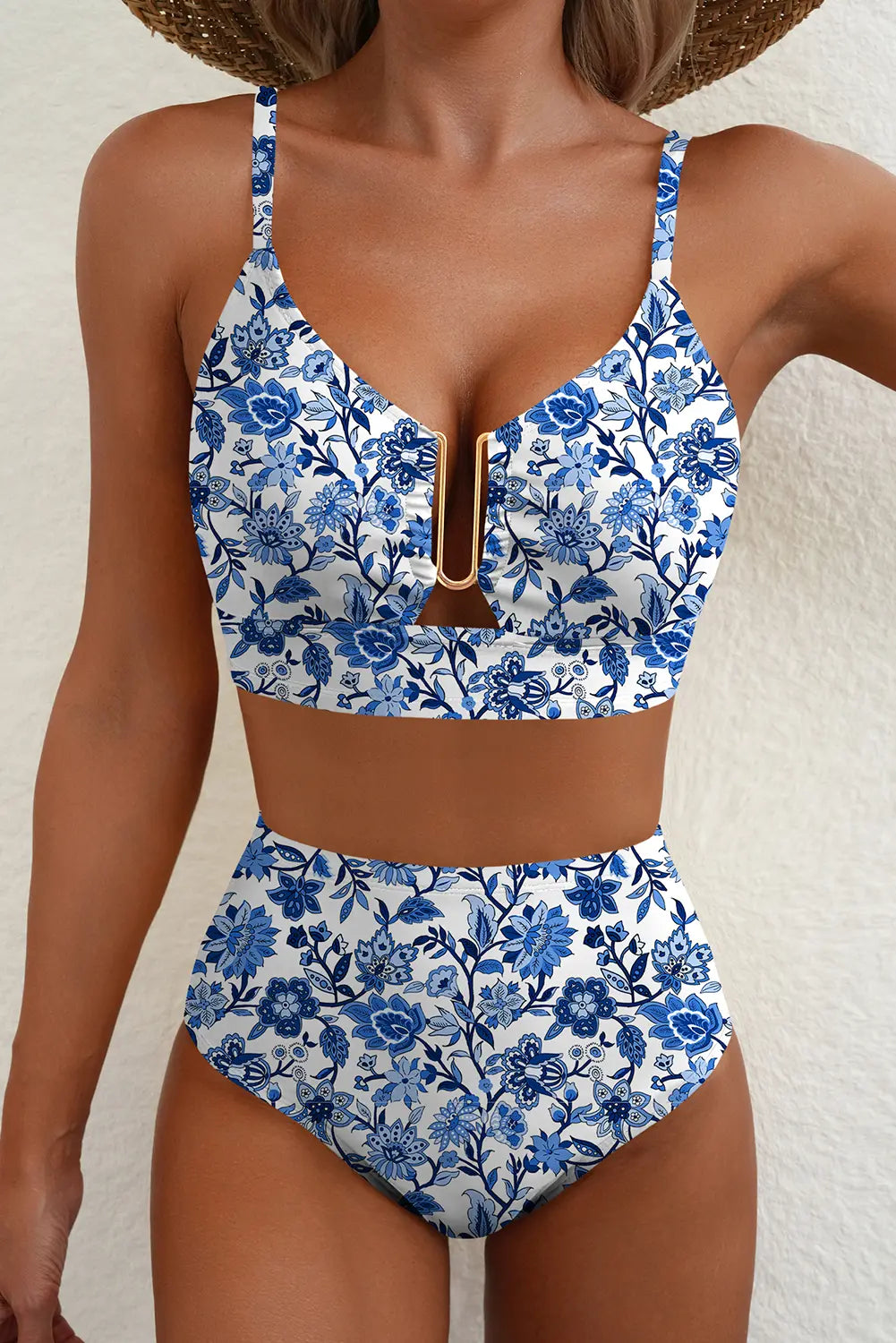 Woman wearing a blue floral bikini set against a white background