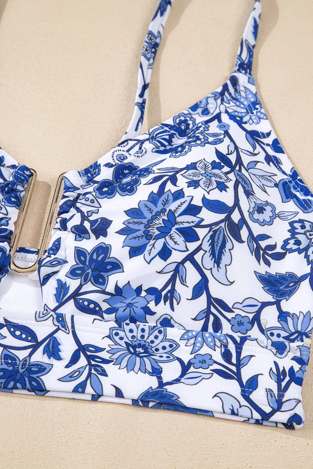 Blue floral-patterned bikini top on a beige background
