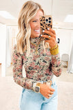Woman taking a mirror selfie wearing a floral top and light blue jeans in a store.