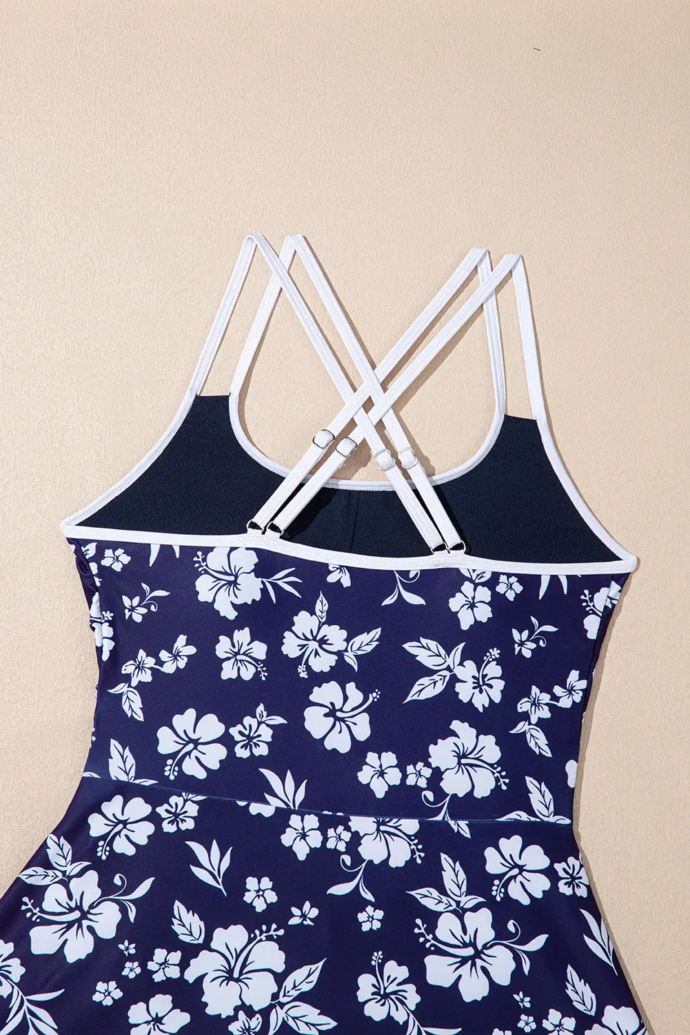 Navy blue tank top with white floral pattern on a beige background