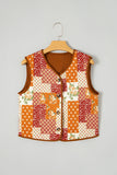 Sleeveless patchwork vest with orange, red, and cream floral patterns hanging on a wooden hanger.