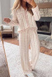 Woman in cream pajama set with pink floral vertical stripes.