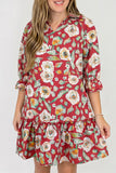 A woman wearing a red floral mini dress with three-quarter ruffled sleeves and a ruffled hem, shown against a plain light gray studio background.