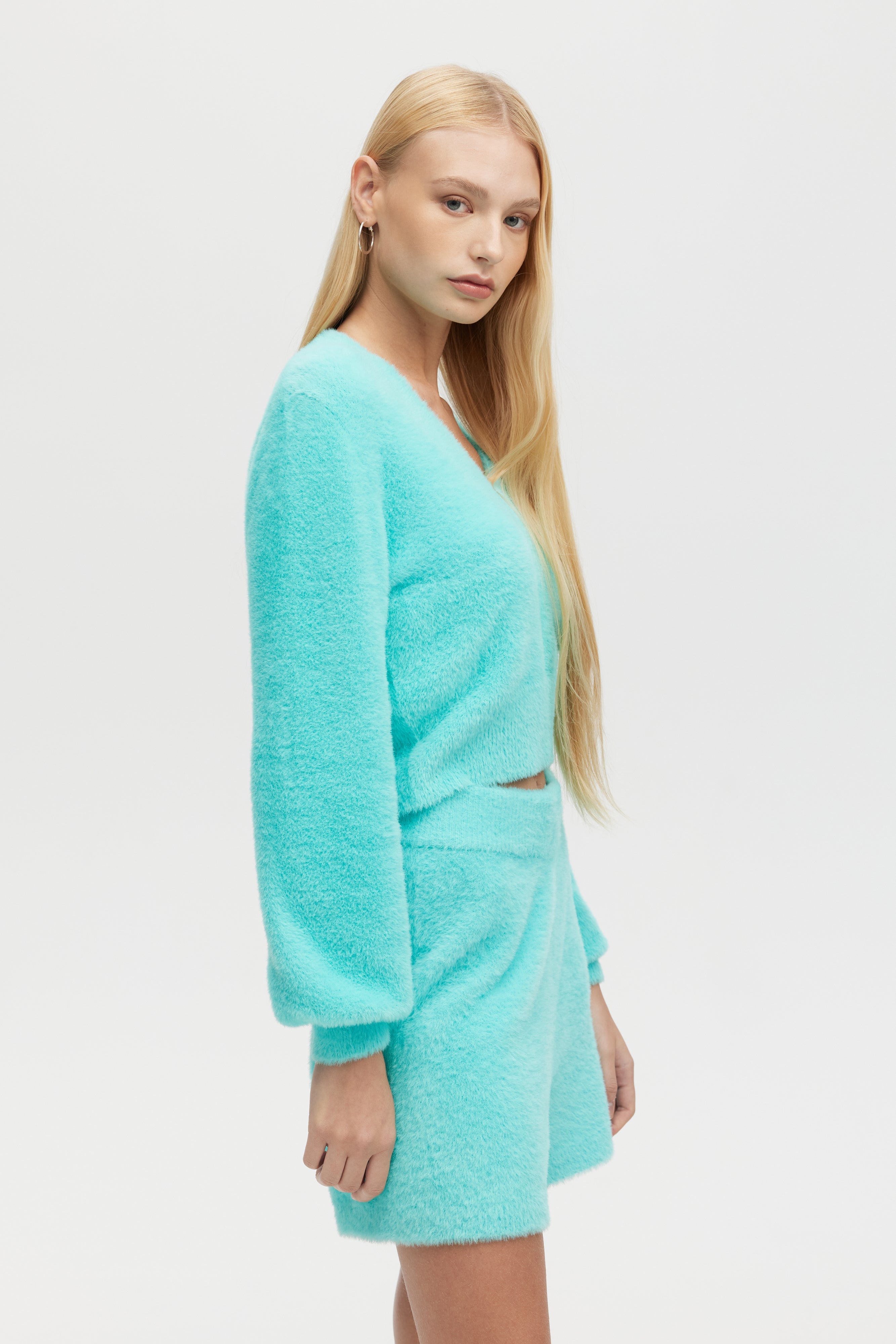 Woman wearing a turquoise dress against a white background