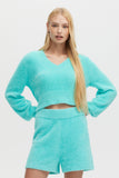 Woman wearing a turquoise outfit on a white background