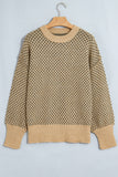 A beige and brown knit sweater with a geometric pattern, hanging on a wooden hanger against a light gray background.