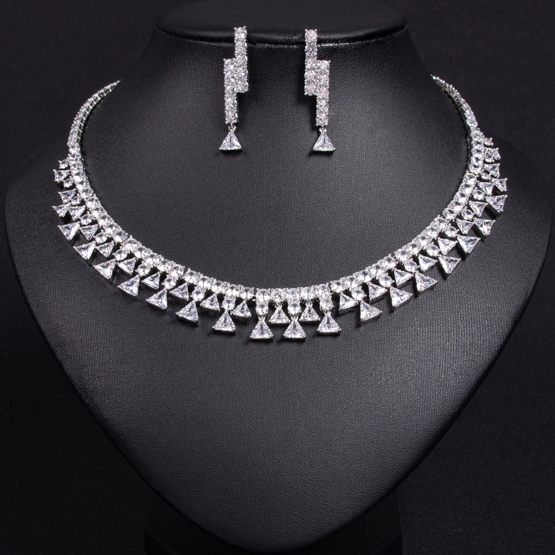Silver necklace and earrings on a black mannequin