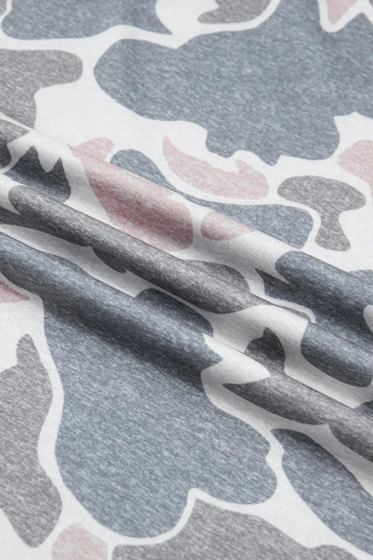 A close-up of a heather gray fabric with an abstract organic camouflage pattern in white, dark gray, and muted dusty pink, draped in soft folds.