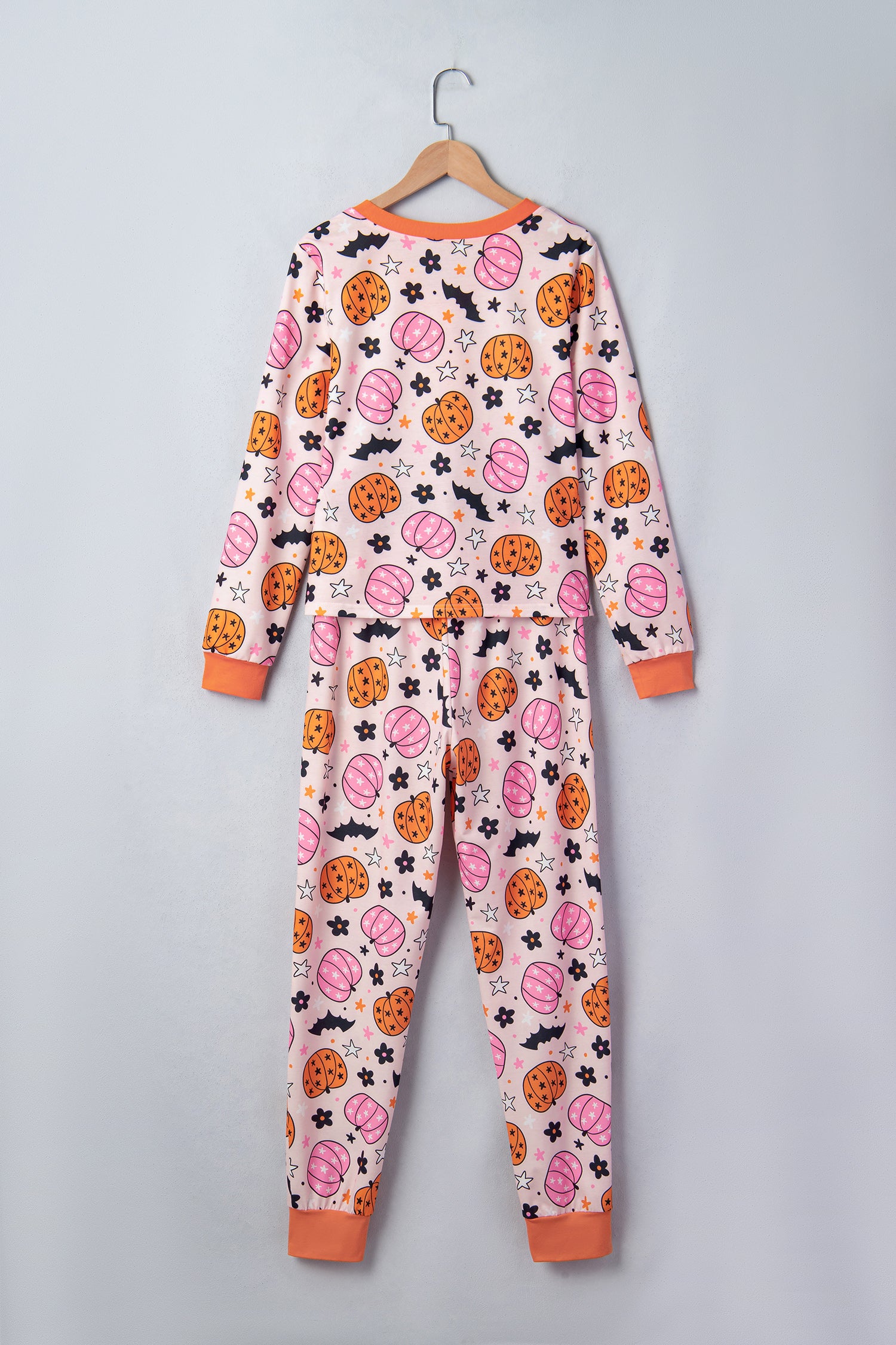 White Halloween-print pajamas with pumpkins, bats, spiders, and orange trim.
