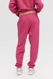 Person wearing a pink tracksuit on a white background