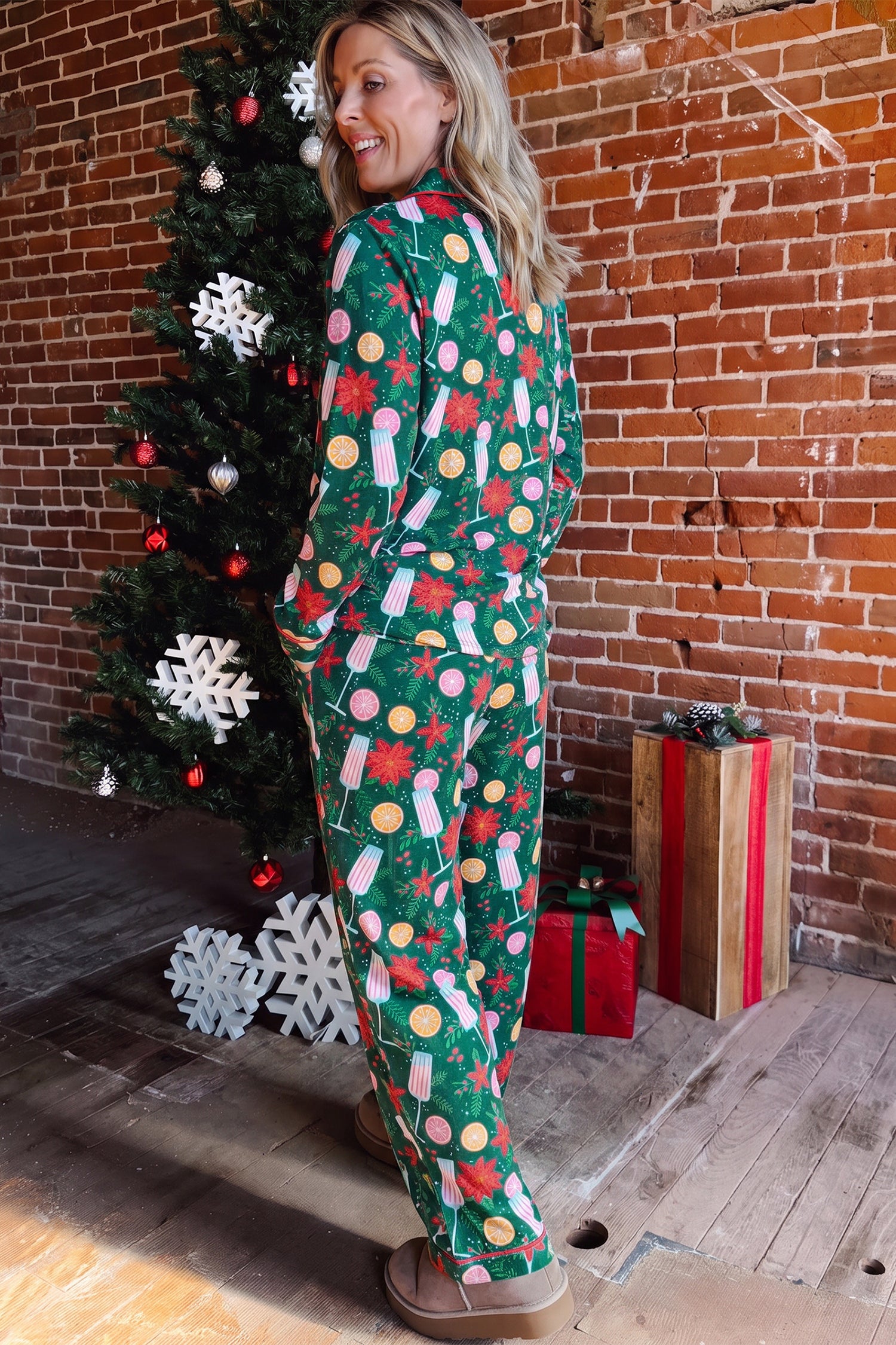 Woman in green Christmas pajamas with candy cane and snowman print.
