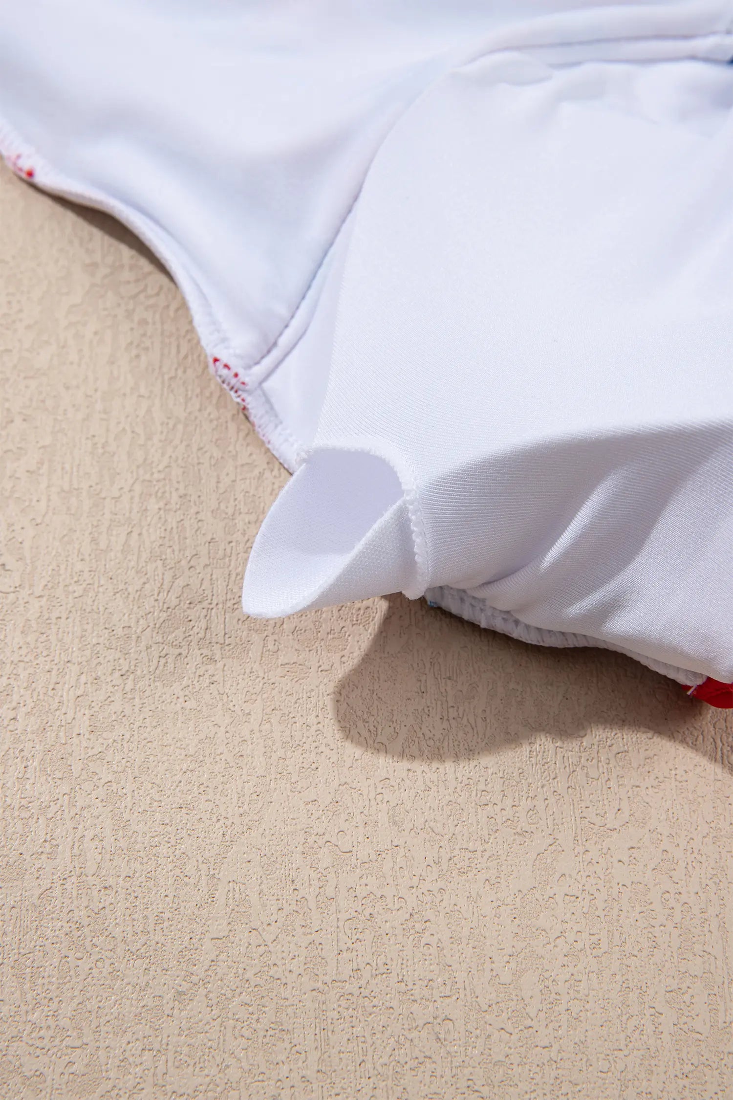 White underwear with a floral pattern on a beige surface