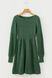 Green knitted dress on a wooden hanger against a white background