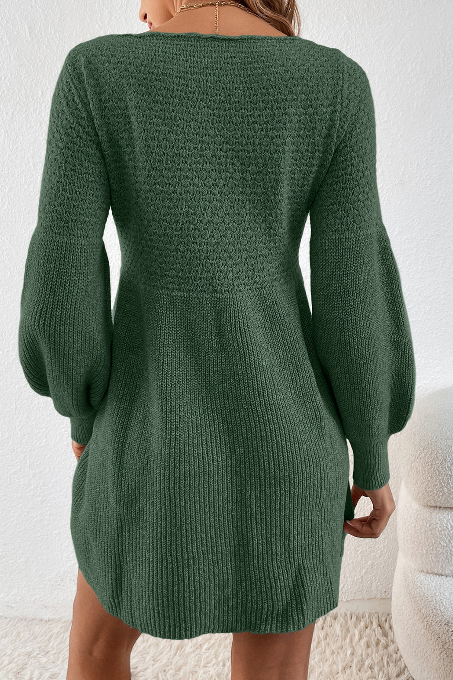 Green knitted dress worn by a person on a white background