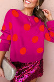 A woman wearing a bright pink knit sweater with large orange-red polka dots, paired with a shiny magenta sequined skirt and holding a silver clutch against a pink wall.