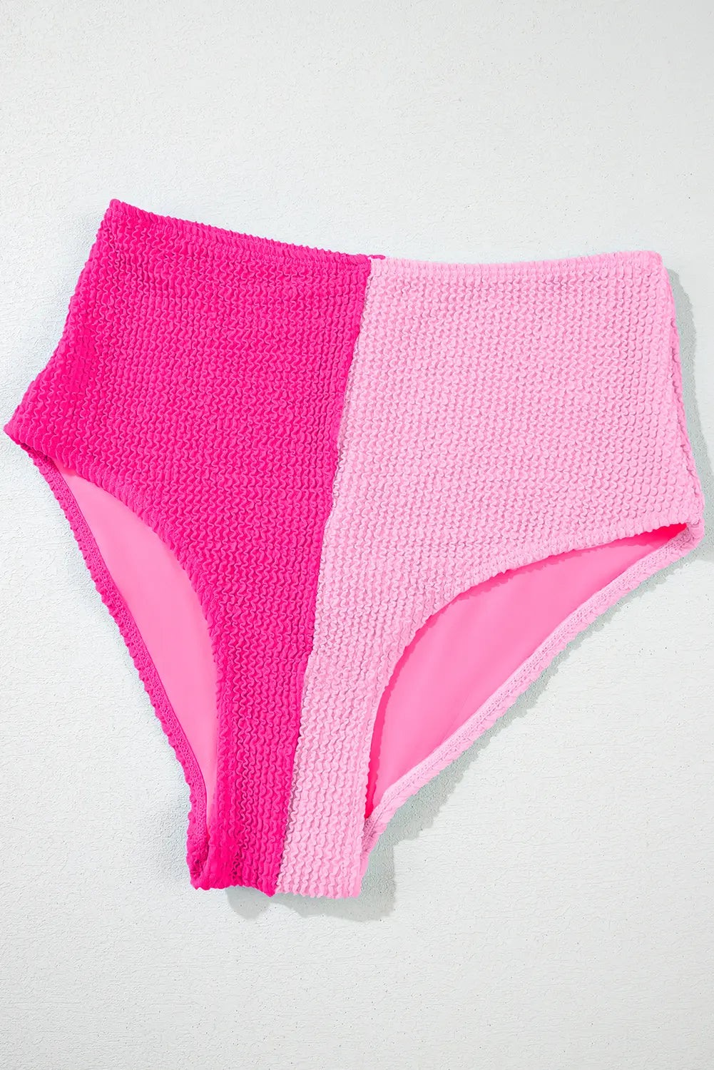 Two pairs of pink high-waisted bikini bottoms on a light gray background