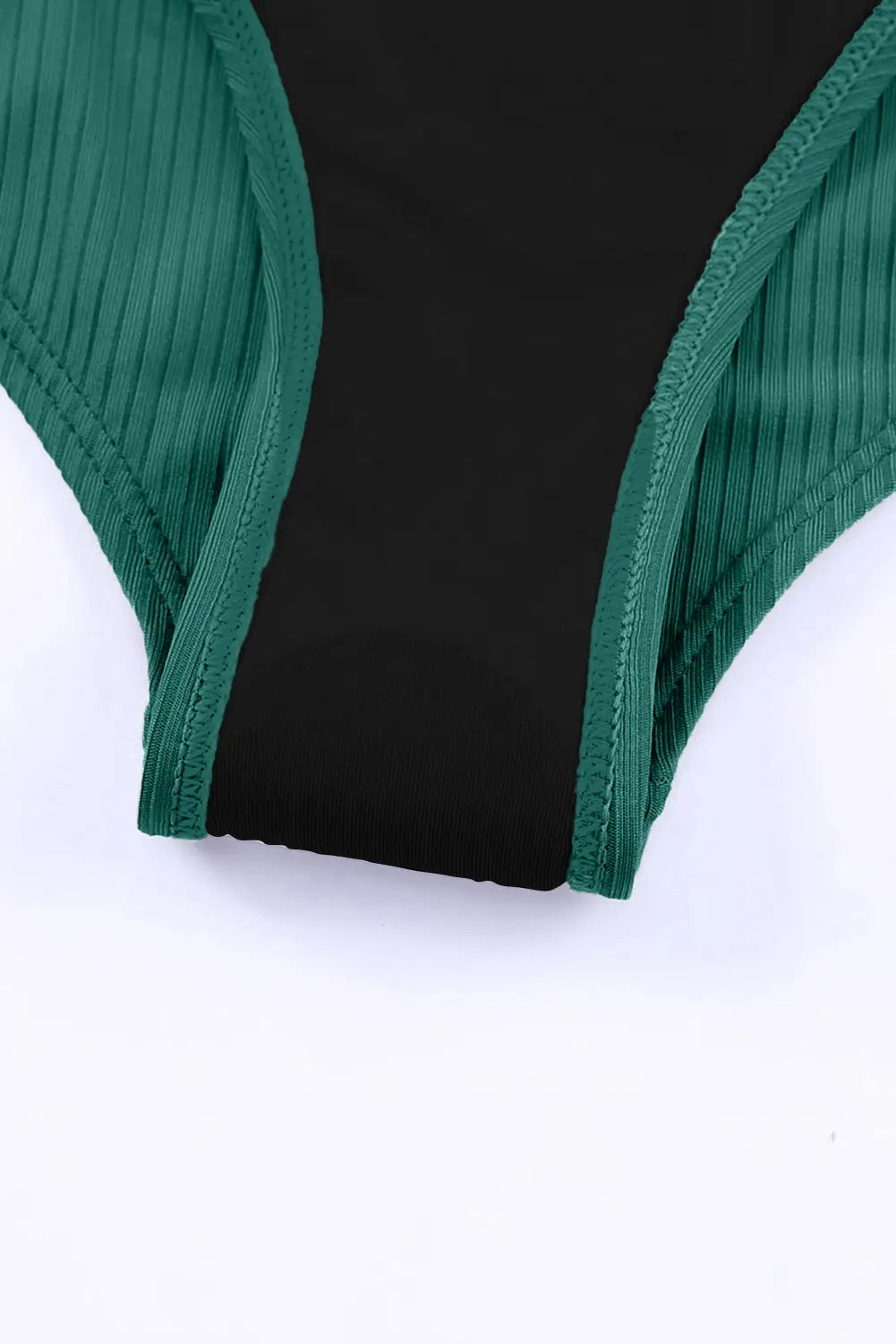Close-up of a green and black swimsuit on a white background