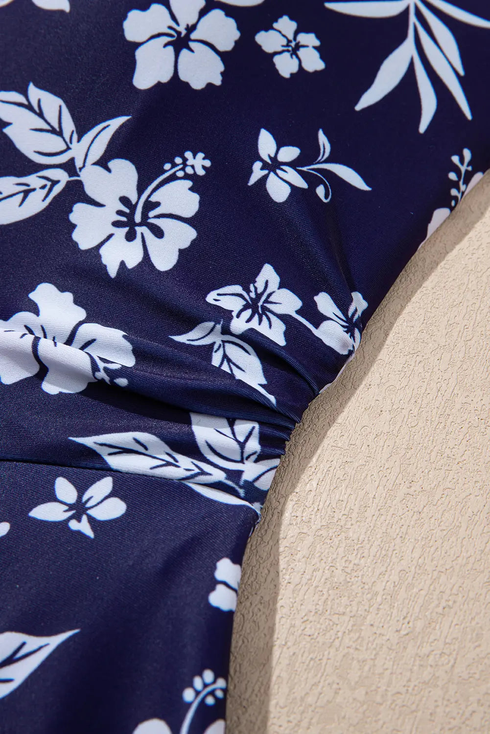 Navy blue fabric with white floral pattern on a beige background