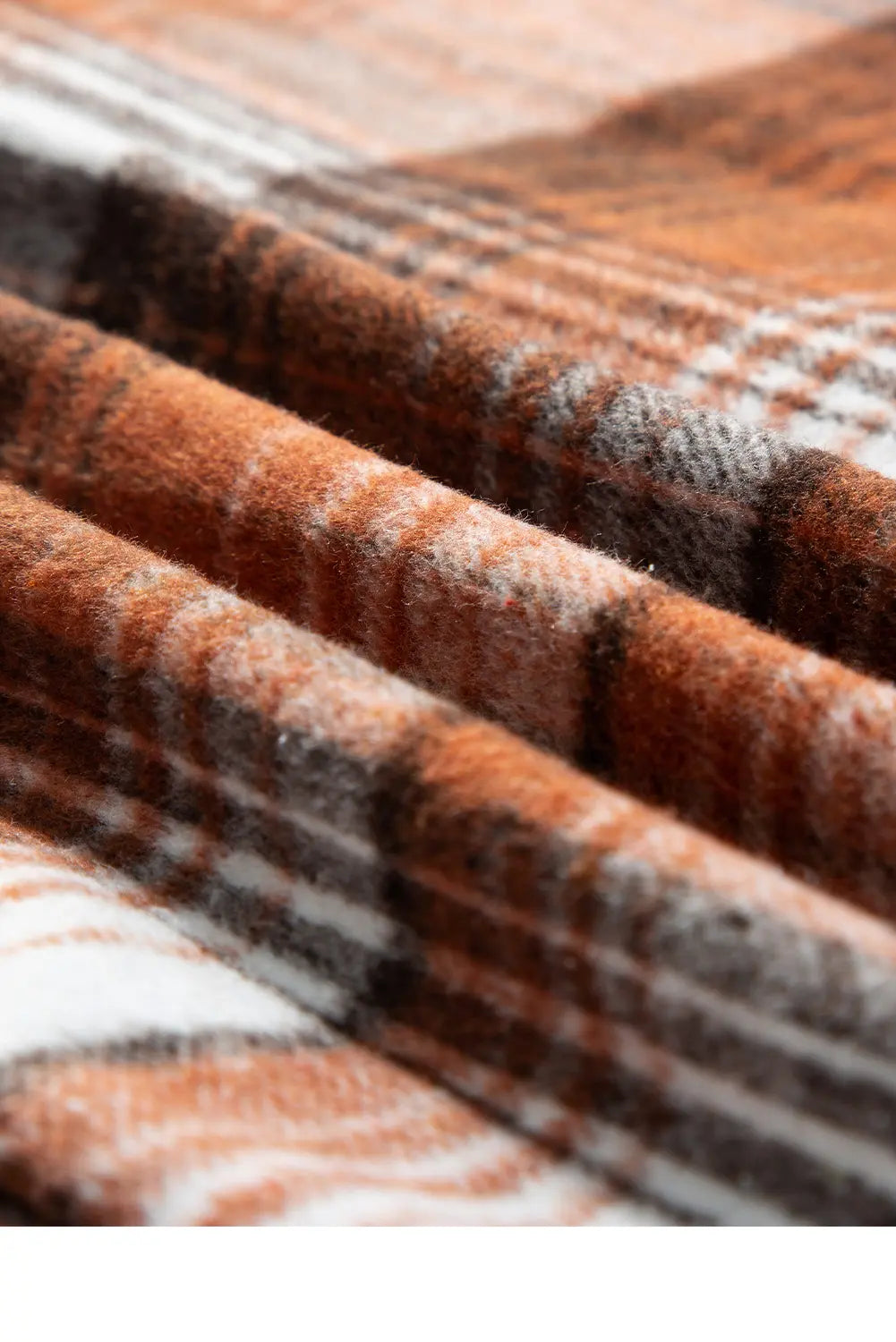 Close-up of a plaid fabric with brown, gray, and white colors.