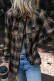 Person wearing a plaid shirt and jeans holding a coffee cup outdoors.