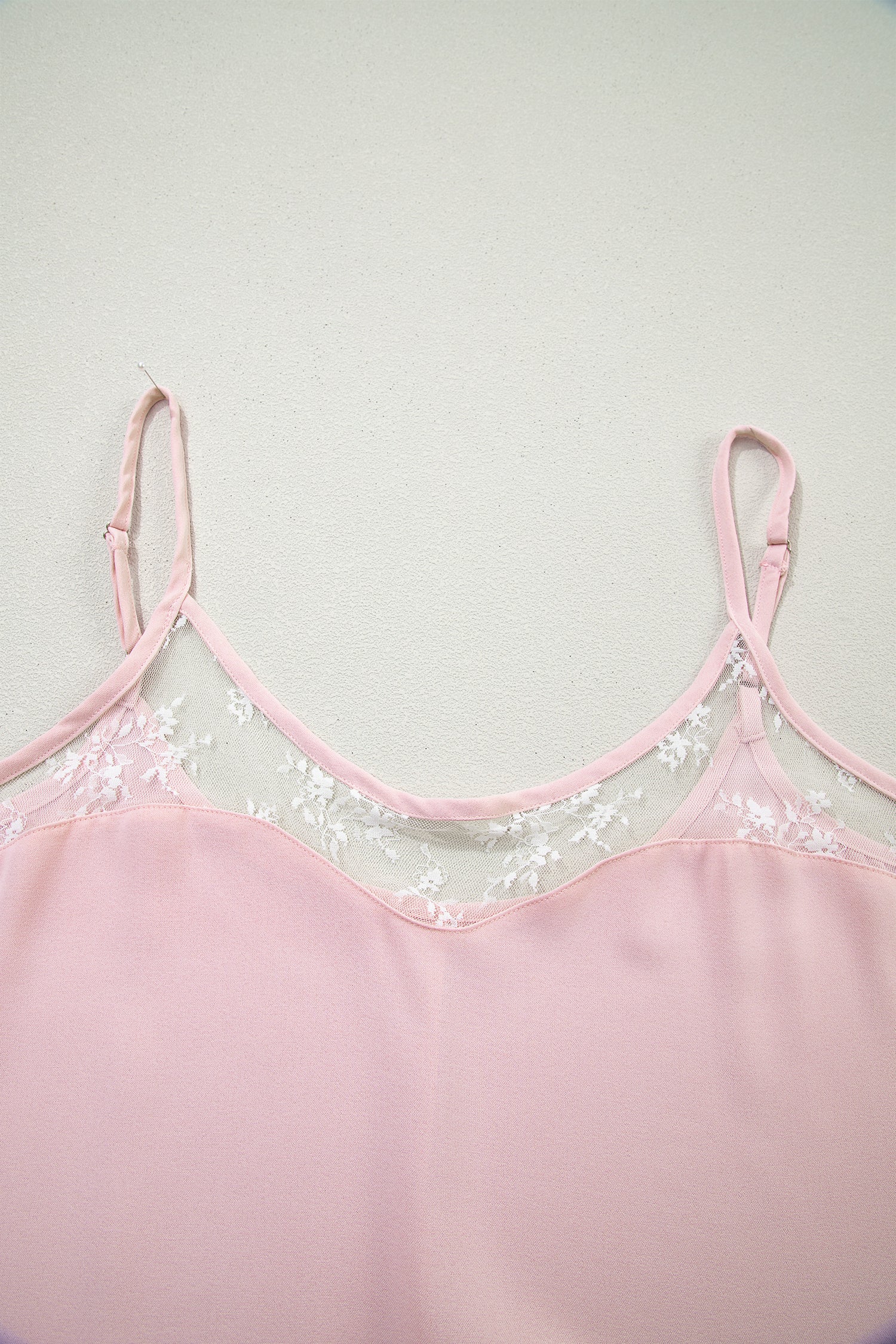 Pink lace-trimmed top on a light gray background