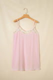 Pink slip dress with lace details on a wooden hanger against a beige background