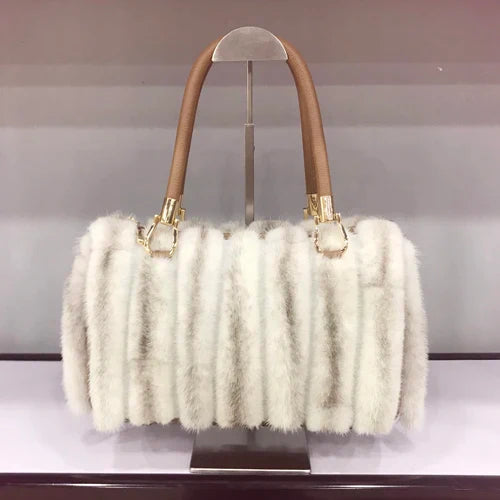 White fluffy handbag with brown handles on a stand