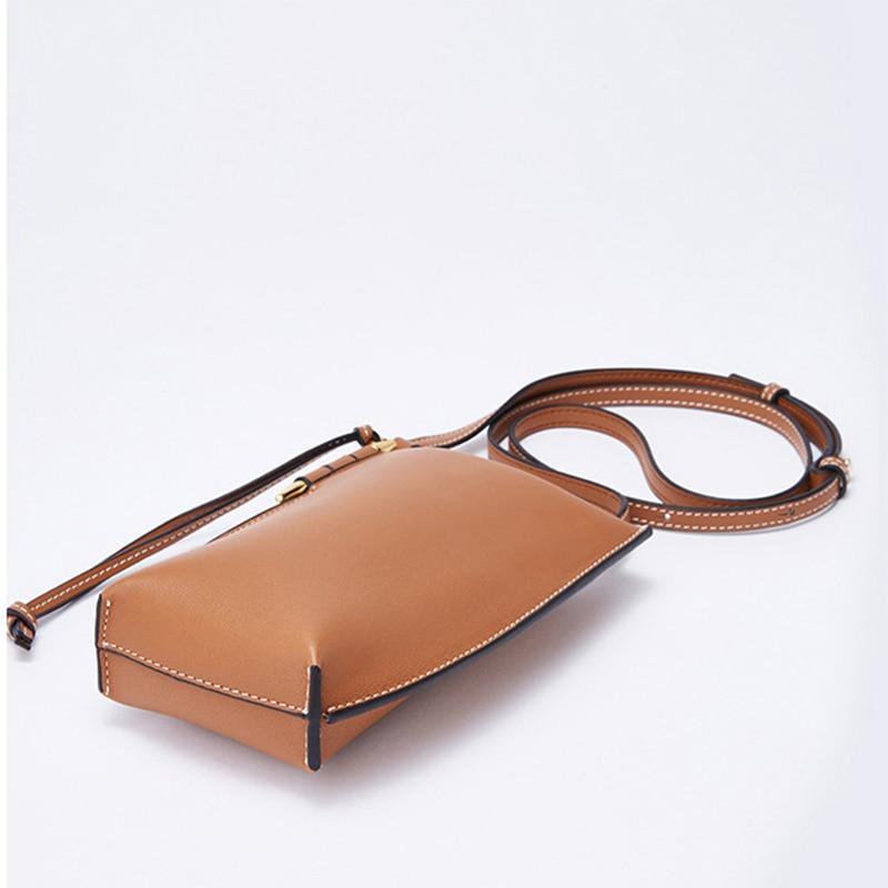 Brown leather handbag with a strap on a white background
