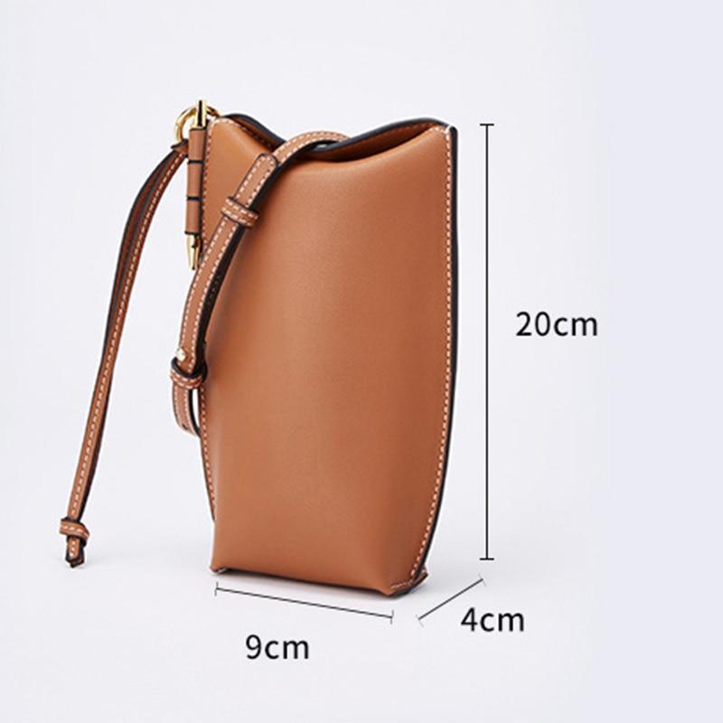 Brown leather handbag with measurements on a light gray background