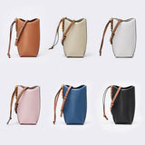 Set of six bucket bags in different colors on a light gray background