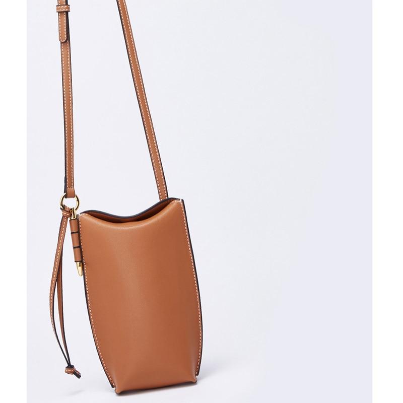 Brown leather crossbody bag on a light gray background