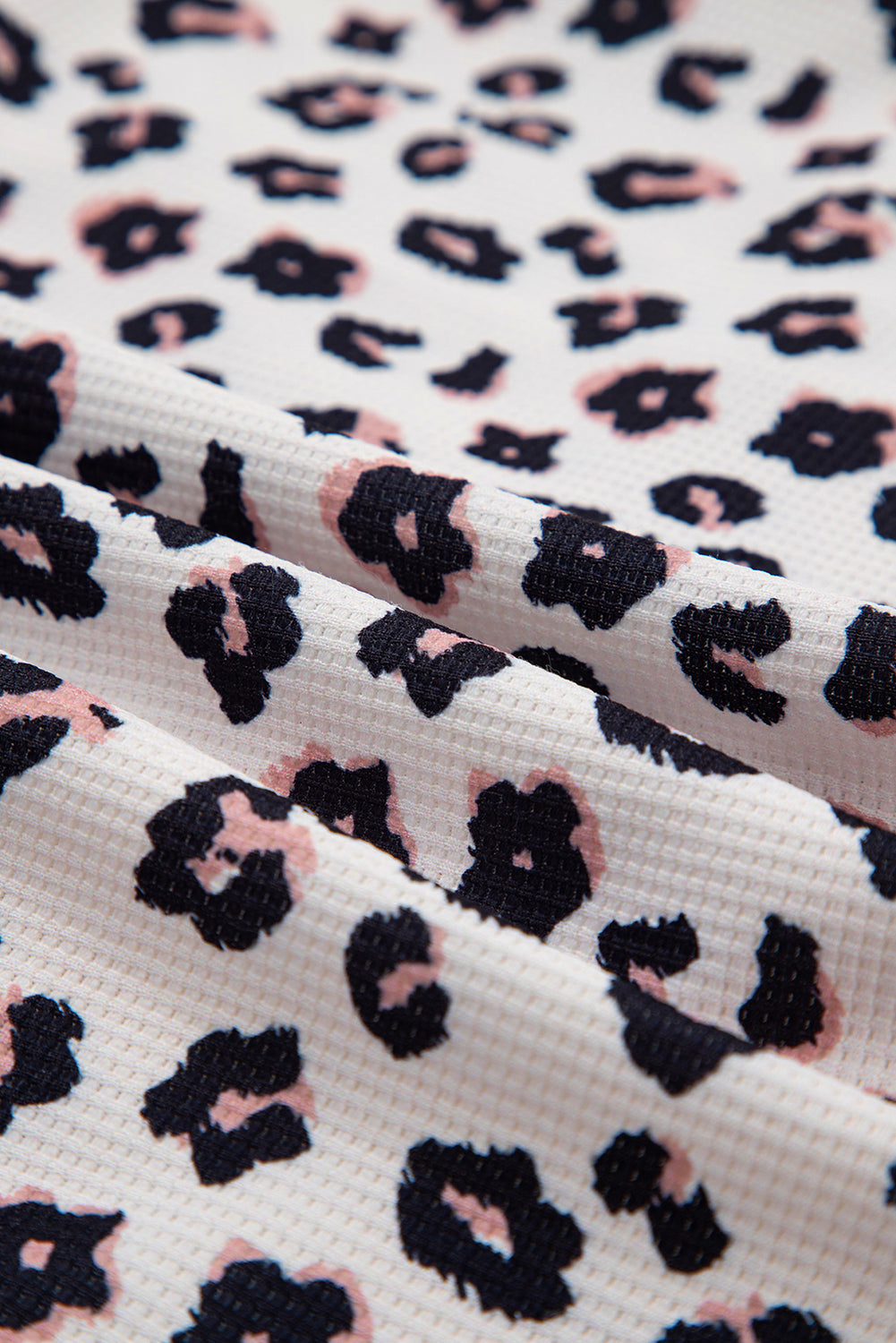 Close-up of fabric with a leopard print pattern on a white background