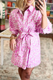 Woman wearing a pink and white patterned dress with a blurred background
