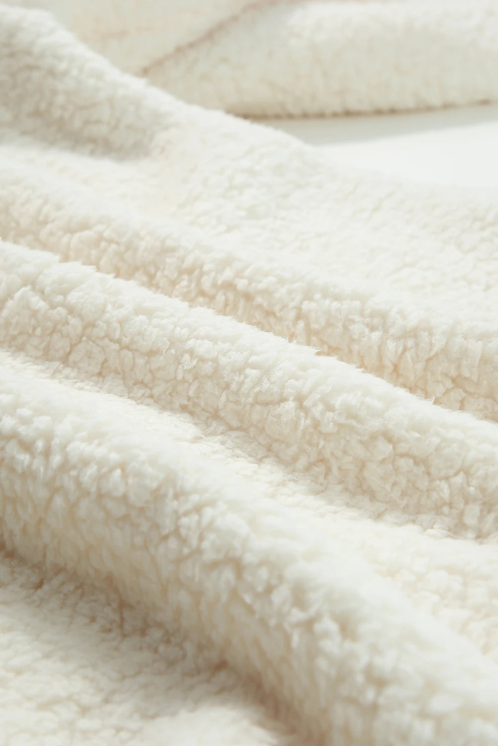 Close-up of a textured beige fabric surface.