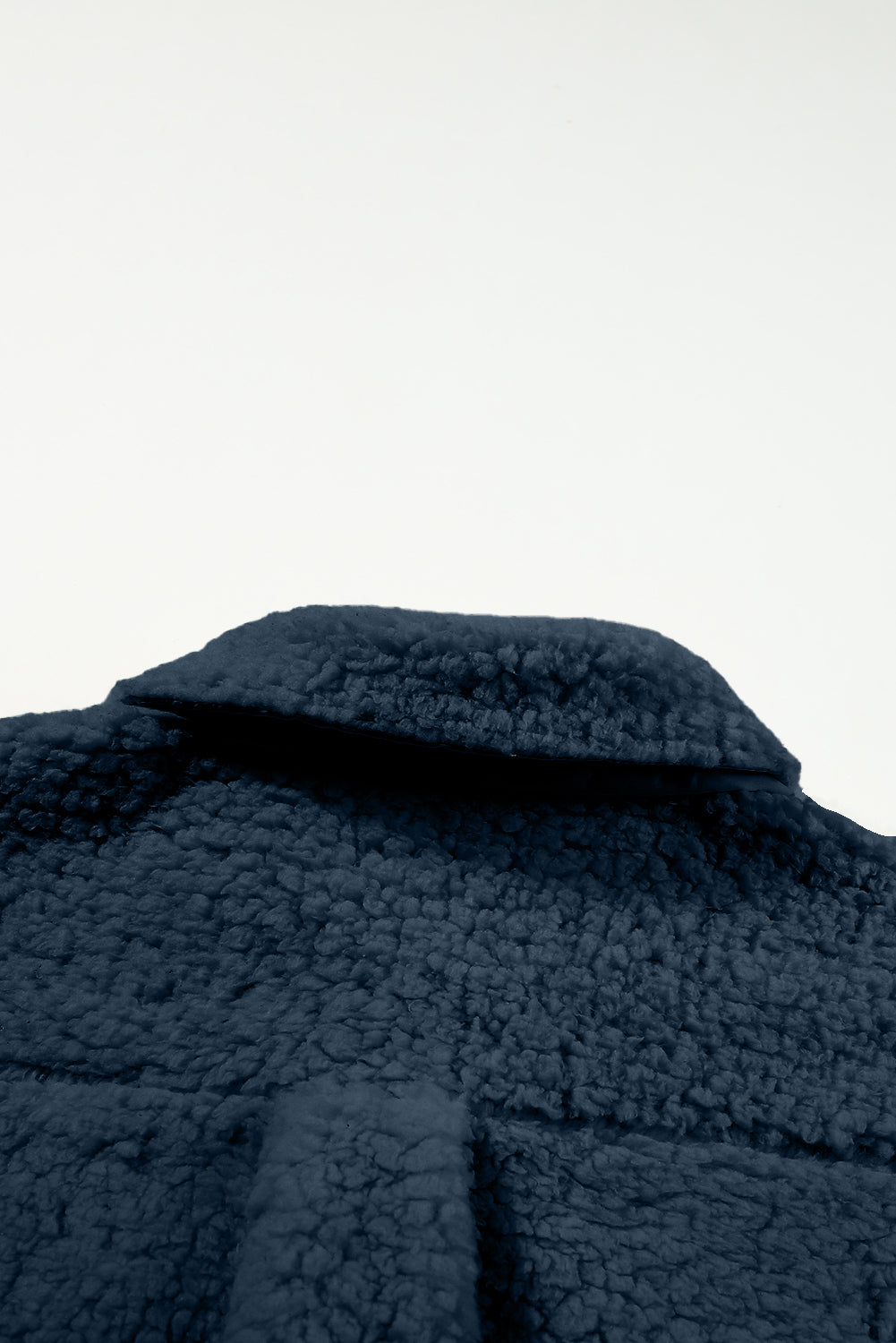 Close-up of a dark blue textured garment on a white background