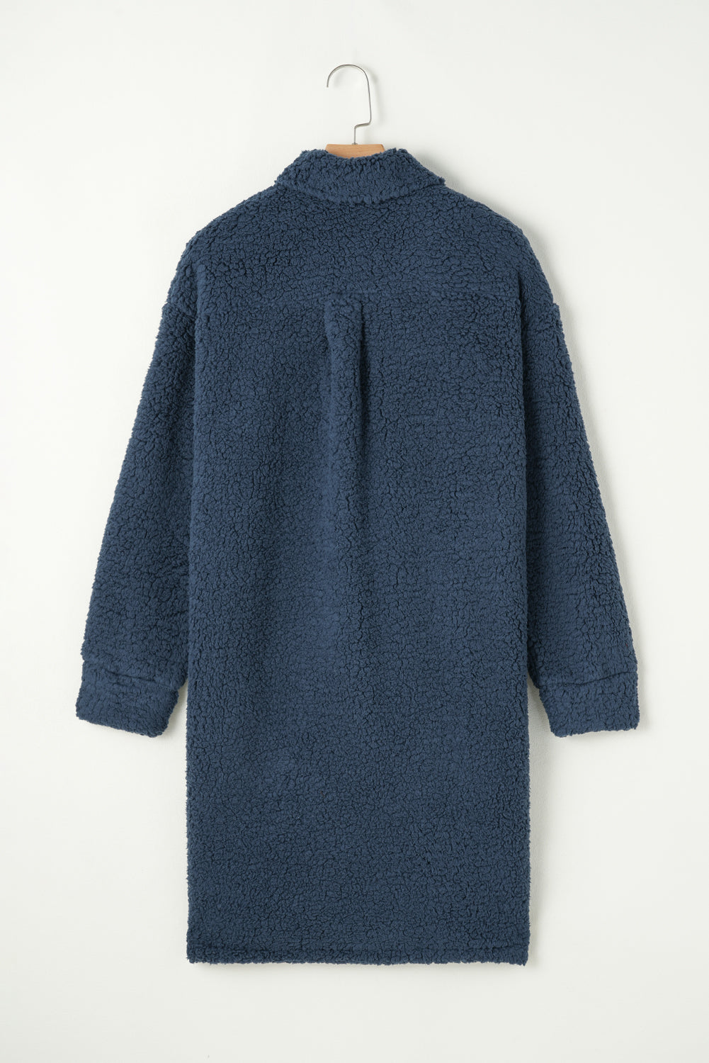 Blue knitted dress on a hanger against a white background.